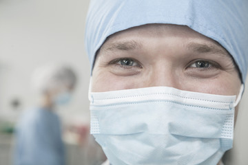 Fototapeta na wymiar Portrait of surgeon with surgical mask and surgical cap in the operating room 