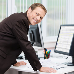 lächelnder geschäftsmann am arbeitsplatz