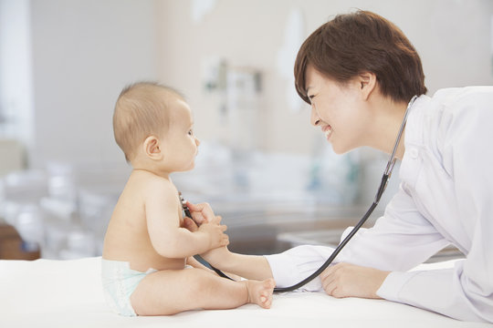 Doctor Checking Baby's Heart Beat With A Stethoscope In The Doctors Office