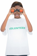 Cheerful volunteer woman looking through binoculars