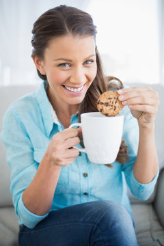 Smiling Woman Dunking Cookie In Coffee