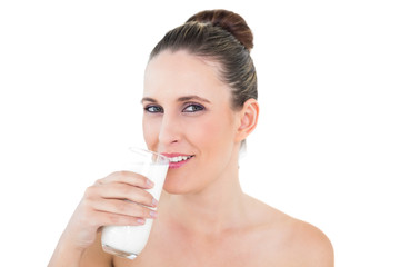 Obraz na płótnie Canvas Happy woman drinking milk and looking at camera