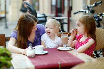 Mother and her daughters relaxing in outdoor cafe