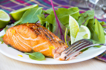 Grilled fillet of red salmon and salad with green leaves of lett