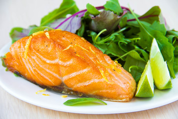 Grilled fillet of red salmon and salad with green leaves of lett