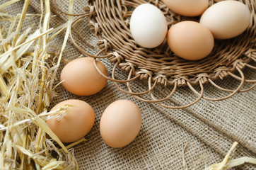 Brown eggs in a wicker plate and sackcloth