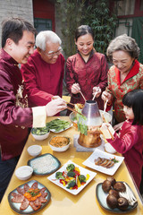 Fototapeta na wymiar Family enjoying Chinese meal in traditional Chinese clothing