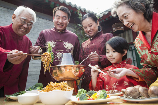 Family enjoying Chinese meal in traditional Chinese clothing