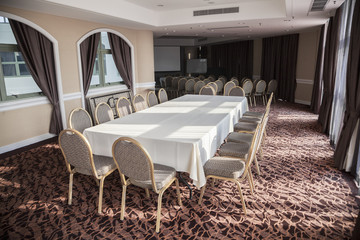 Empty conference room with presentation screen and long table.