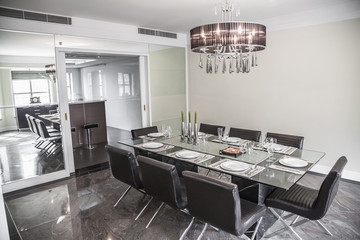 Dining room with modern furniture and chandelier. 