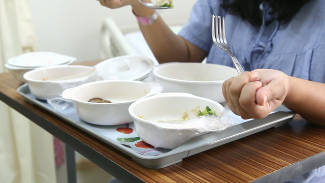 Patient girl have soft special meal on bed in hospital room