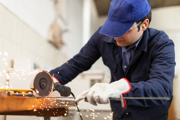 Worker grinding a metal plate