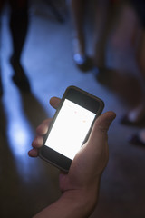 A young man uses a mobile phone in nightclub
