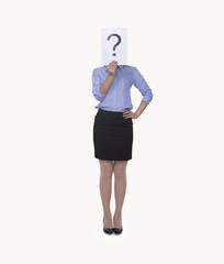 Young businesswoman holding at paper with a question mark on it, obscured face, studio shot