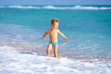 cute kid boy having fun in sea surf