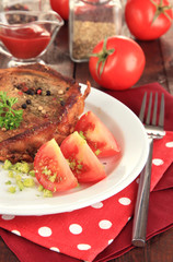 Piece of fried meat on plate on wooden table close-up