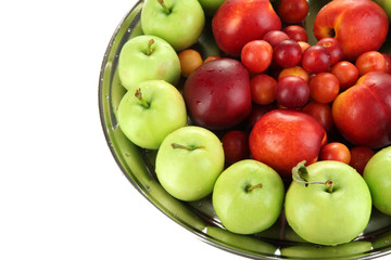 Assortment of juicy fruits on plate, isolated on white