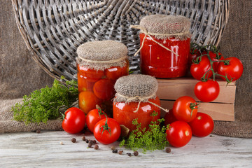 Tasty canned and fresh tomatoes on wooden table