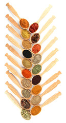 Assortment of spices in wooden spoons, isolated on white