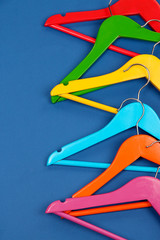 Colorful clothes hangers on blue background