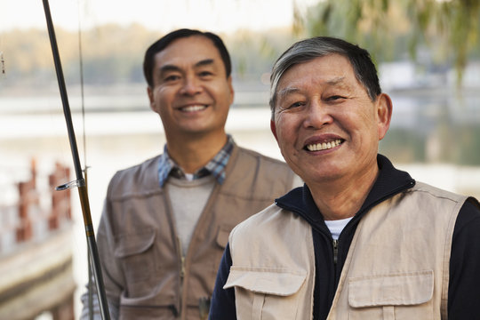 Senior Friends Portrait While Fishing At A Lake