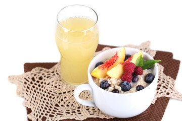Oatmeal in cup with berries on napkins isolated on white