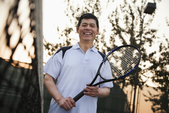 Senior men playing tennis, portrait
