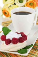 Tasty meringue cake with berries and cup of coffee