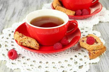 Cups of tea with cookies and raspberries on table close-up