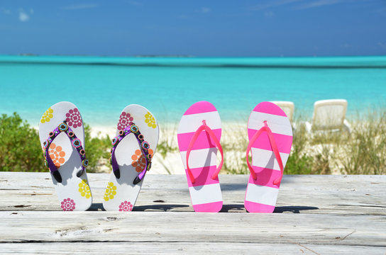 Two pairs of flip-flops against Atlantic. Exuma, Bahamas
