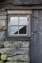 Alte Holztür mit Fenster in Steinmauer