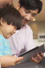 Fototapeta premium Son and his parents using digital tablet 
