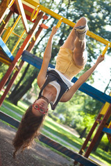 Young woman in the playground upside down