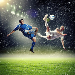 Obraz na płótnie Canvas two football players striking the ball