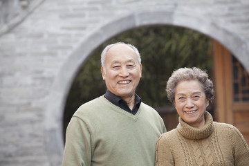 Portrait of senior couple in front of round arch, Beijing