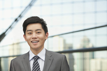 Portrait of young businessman with cityscape in background, Beijing, China