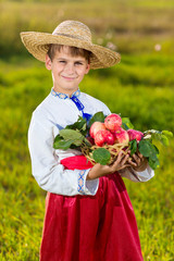 Happy farmer boy hold Organic Apples in Autumn Garden