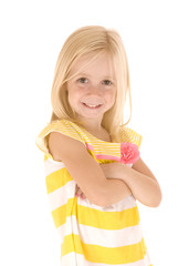 Young blonde girl in yellow striped shirt standing with arms fol