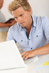 Portrait of smiling attractive young man in office