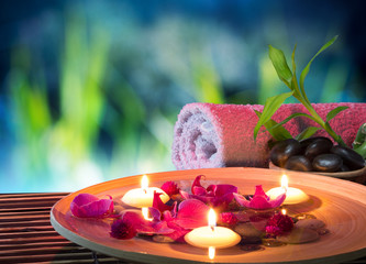 dish spa with floating candles, orchid, bambu towel in garden