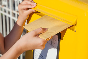 Woman inserting envelope in mailbox