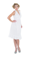 Stylish fashion blonde model posing with a hand on the hip