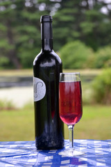 Wine Bottle and Glass on a Picnic Table
