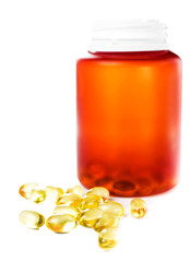 Shiny yellow vitamin E omega 3 fish oil capsules and pill bottle
