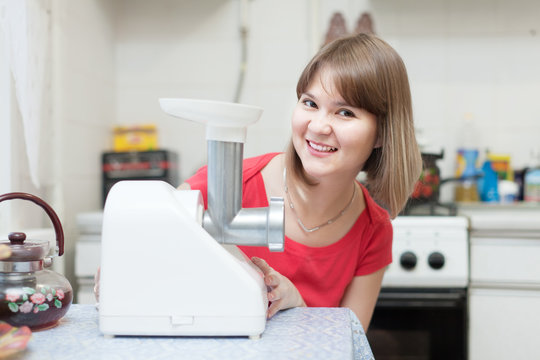 Woman with electric meat comminutor