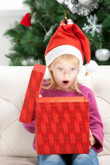 What a surprise! Surprised little girl opening Christmas gift bo