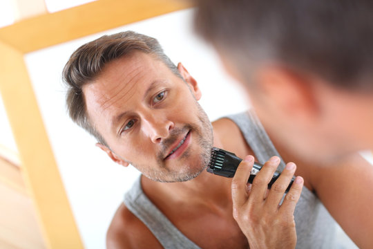 Handsome Guy Shaving In Front Of Mirror