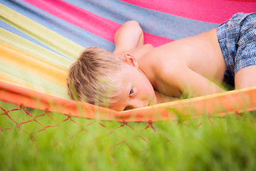 Calm little boy quietly  lying in hammock