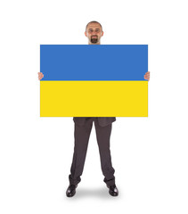 Smiling businessman holding a big card, flag of Ukraine