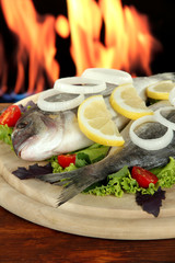 Dorado fish on table on fire background